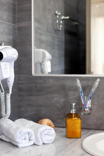 a bathroom with a sink and a soap dispenser on a counter at Villa Dina with private Juccuzi in Perissa