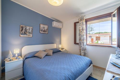 Dormitorio azul con cama y ventana en Villa Emerald, en Reitani