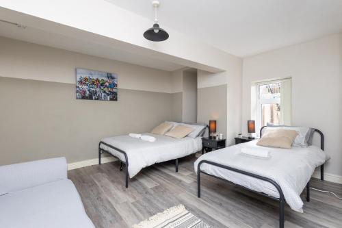 Habitación con 2 camas y sofá en Manygates Contractor Retreat - Near Wakefield Centre, Off Road Parking, High Speed Wi-Fi, Self Check-in, en Wakefield