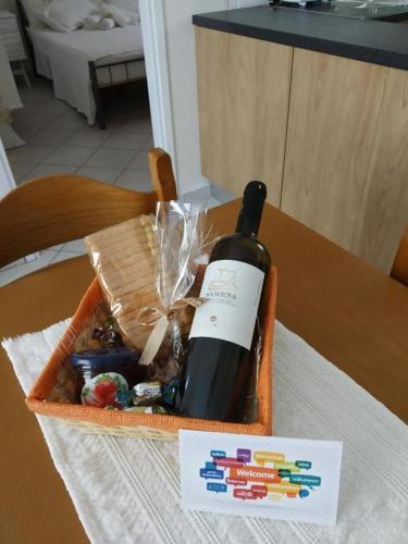 a bottle of wine in a basket on a table at Alpha apartment, Ireon Samos in Iraion