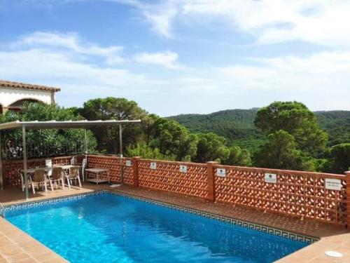 una piscina frente a una pared de ladrillo en Casa aire, en Pals