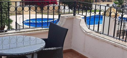 einen Balkon mit einem Tisch, Stühlen und einem Zaun in der Unterkunft La Manga Club Townhouse in Cartagena