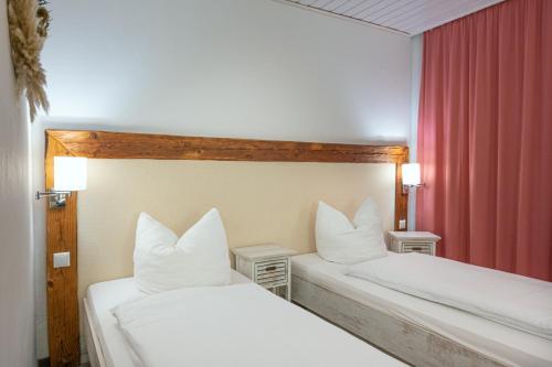 two beds with white pillows in a hotel room at Landgasthof Stricker in Bad Rodach