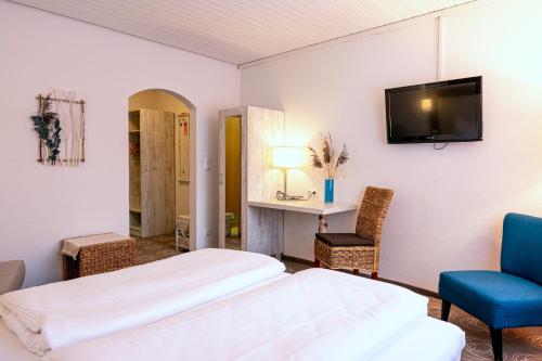 a bedroom with two beds and a tv on the wall at Landgasthof Stricker in Bad Rodach