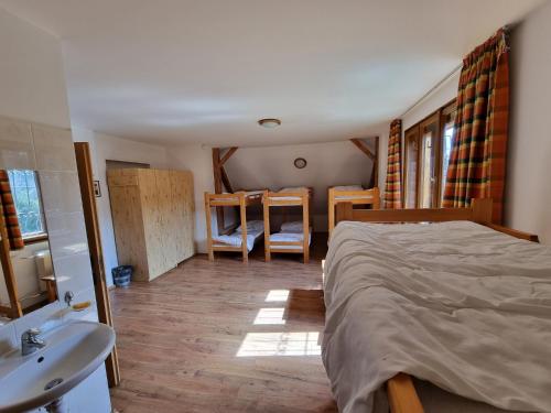 een slaapkamer met een bed en een badkamer met een wastafel bij Chata Horáreň in Smižany