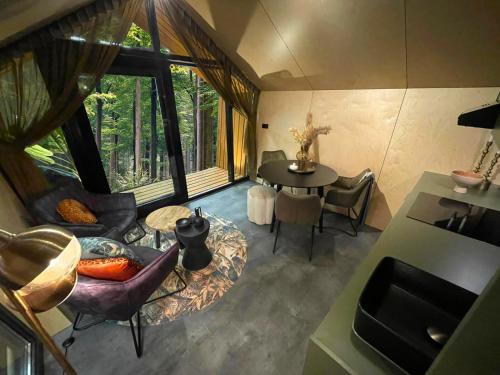 a room with a table and chairs in a room with a window at Diamond Suite in the woods in Holten