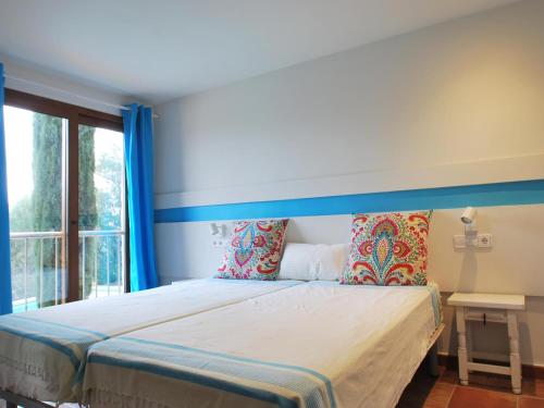 a bedroom with a bed with a blue headboard and a window at Dalí in Begur