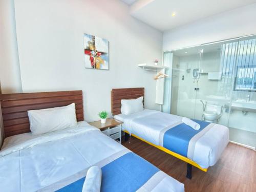 a bedroom with two beds and a bath room at The Riverbank Hotel By MRVJ Business in Kuantan