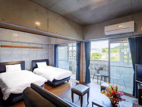 a hotel room with two beds and a couch at 名護パークサイドコンドミニアムTKステイ in Nago