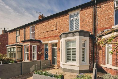 a red brick house with a white door at Hollie Cottage in Lytham St Annes