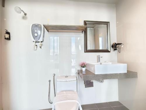 a bathroom with a sink and a toilet and a mirror at Riverbank Kuantan by Glex in Kuantan