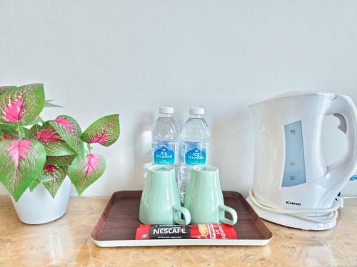 a table with two bottles of water and a blender at The Riverbank Hotel By MRVJ Business in Kuantan