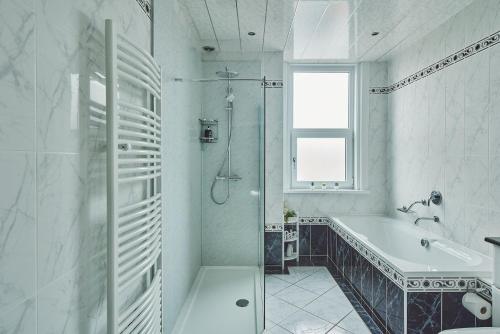 uma casa de banho branca com uma banheira e um lavatório em Hollie Cottage em Lytham St Annes