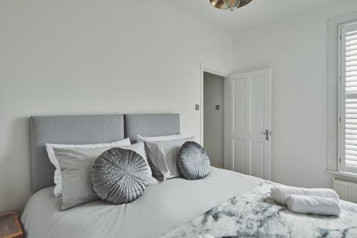 Una cama blanca con dos almohadas encima. en Hollie Cottage en Lytham St Annes