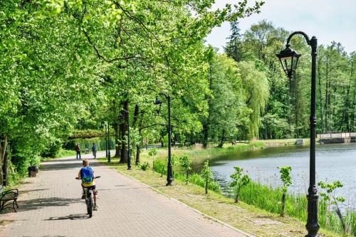 斯巴拉的住宿－Dom z Ogrodem w Spale，骑着自行车沿着河边的小路骑行的人