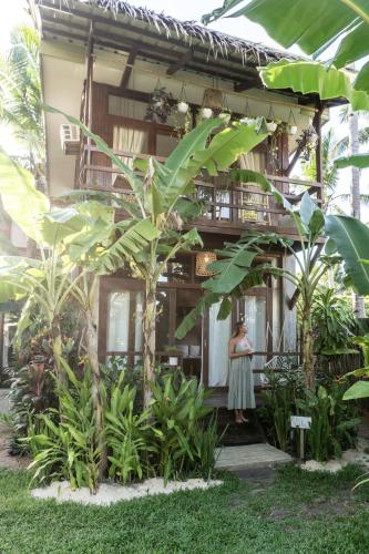 une femme debout devant un bâtiment avec des plantes dans l'établissement Mango Tango Villas Siargao, à General Luna