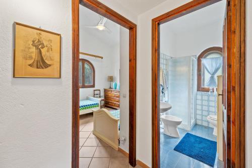 a bathroom with a toilet and a sink and a mirror at Villa Viola in Torre delle Stelle