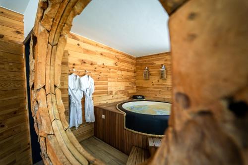 baño de madera con bañera de hidromasaje en Le Fermage - logement avec piscine, sauna et jacuzzi, 