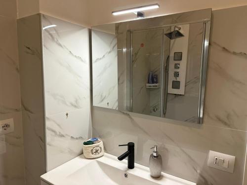 bagno bianco con lavandino e specchio di Pash room a Pero