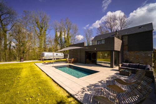 un patio trasero con piscina y una casa en Le Fermage - logement avec piscine, sauna et jacuzzi, 