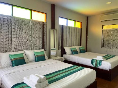 um quarto com 2 camas e 2 janelas em GrandmaD em Chiang Rai