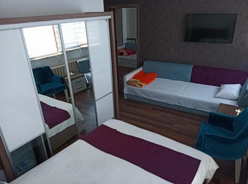 a small room with a bed and a mirror at Garra Hotel in Konya