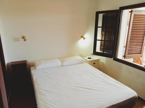 a bedroom with a white bed and a window at Josep in Begur