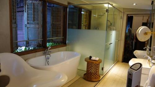 馬六甲的住宿－The Opposite Place，大型浴室设有浴缸和淋浴。