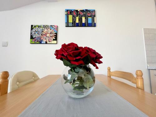 a vase filled with red roses sitting on a table at Old Town Rab Pjaceta Accommodation in Rab