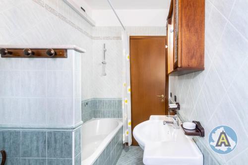 uma casa de banho com um lavatório, uma banheira e um WC. em Luminoso a due passi dal mare 51a em Montesilvano