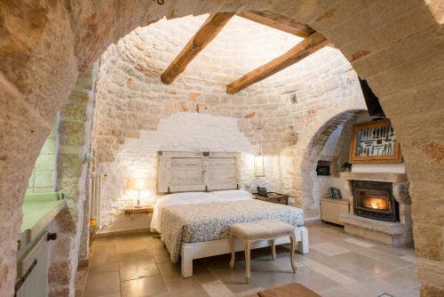 a bedroom with a bed in a stone wall at Trulli Holiday Albergo Diffuso in Alberobello