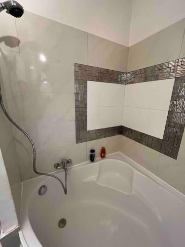 bañera blanca con grifo en el baño en Appartement atypique et original, en Niza
