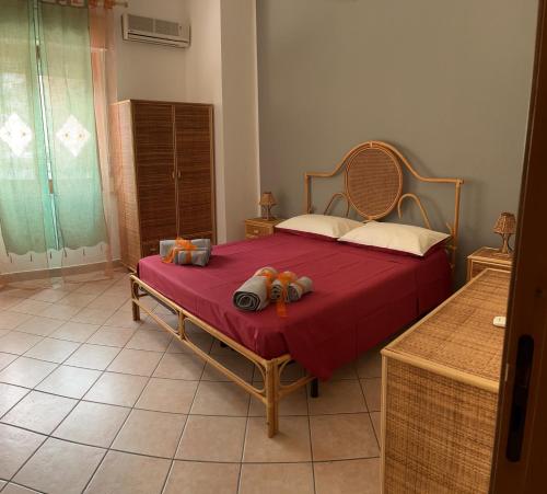 a bedroom with a bed with a red bedspread at DIP IN SICILY in Lentini