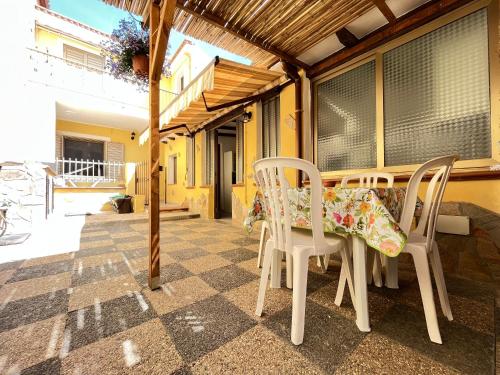 a table and chairs on the porch of a house at Appartamento Nassia 2 By La Via Del Mare Viaggi e Vacanze in Villasimius