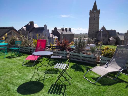 a group of chairs and a table in a yard at Maison centre bourg Port-Bail in Portbail