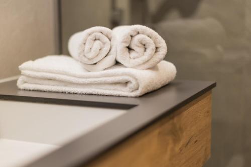 einen Haufen Handtücher auf einer Theke im Bad in der Unterkunft Residenz Schiestl in Fügenberg
