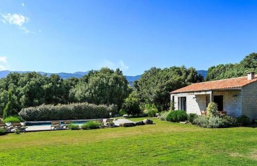 a house with a yard with a pool and trees at Domaine de Peretti della Rocca in Figari