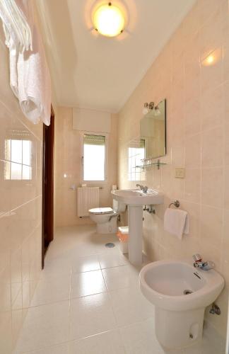 a white bathroom with a sink and a toilet at Santa Cruz in Ribadeo
