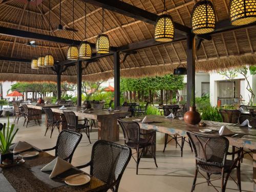restauracja na świeżym powietrzu ze stołami, krzesłami i światłami w obiekcie Sudamala Resort, Senggigi, Lombok w mieście Senggigi