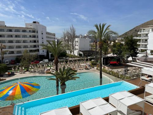 a swimming pool with chairs and an umbrella at VIVA Sunrise in Port d'Alcudia