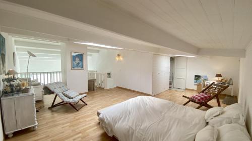 - une chambre avec un lit et deux chaises dans l'établissement Les Pieds dans l'Eau, vue sur la baie pour 6 pers, au Crotoy