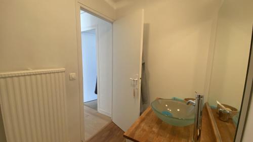 une salle de bain avec un lavabo en verre sur un plancher en bois dans l'établissement Les Pieds dans l'Eau, vue sur la baie pour 6 pers, au Crotoy