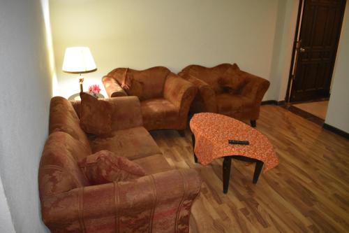a living room with two couches and a table at Grand Regency Hotel in Pothi