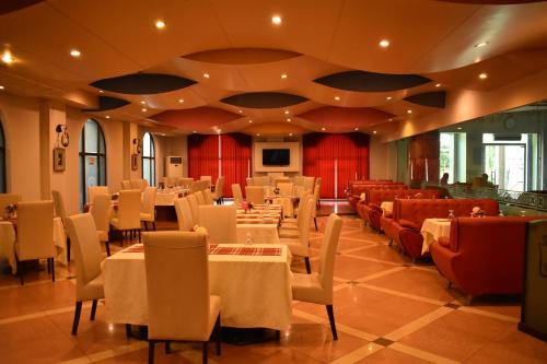 une salle à manger avec des tables et des chaises blanches dans l'établissement Grand Regency Hotel, à Pothi