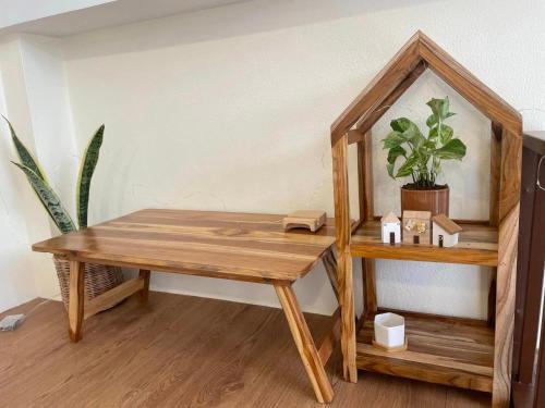 una mesa de madera y un estante con una maceta en KeawKangNa Farmstay แก้วก๋างนา ฟาร์มสเตย์ en Ban Chong (1)