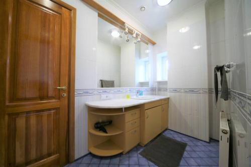 a bathroom with a sink and a wooden door at Old town 2 bedroom / Top location in Rīga
