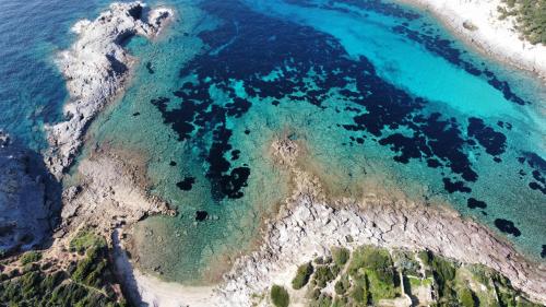 an aerial view of a beach with blue water at Camping Tonnara in Cala Sapone