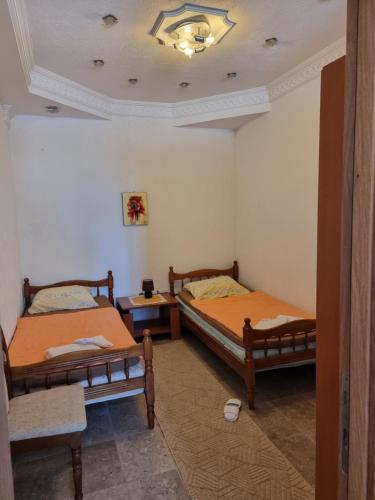 a room with two beds and a table at Apartman LOKI in Ulcinj