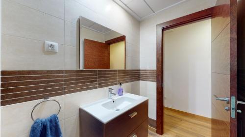 La salle de bains est pourvue d'un lavabo et d'un miroir. dans l'établissement Edificio Galerias, à Lorca