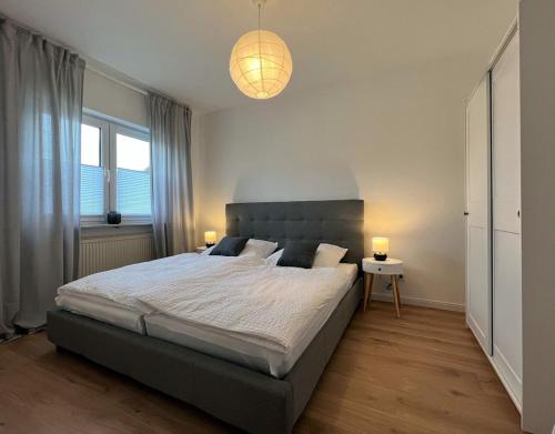 een slaapkamer met een groot bed en 2 lampen bij Ferienwohnung an der Saar in Konz